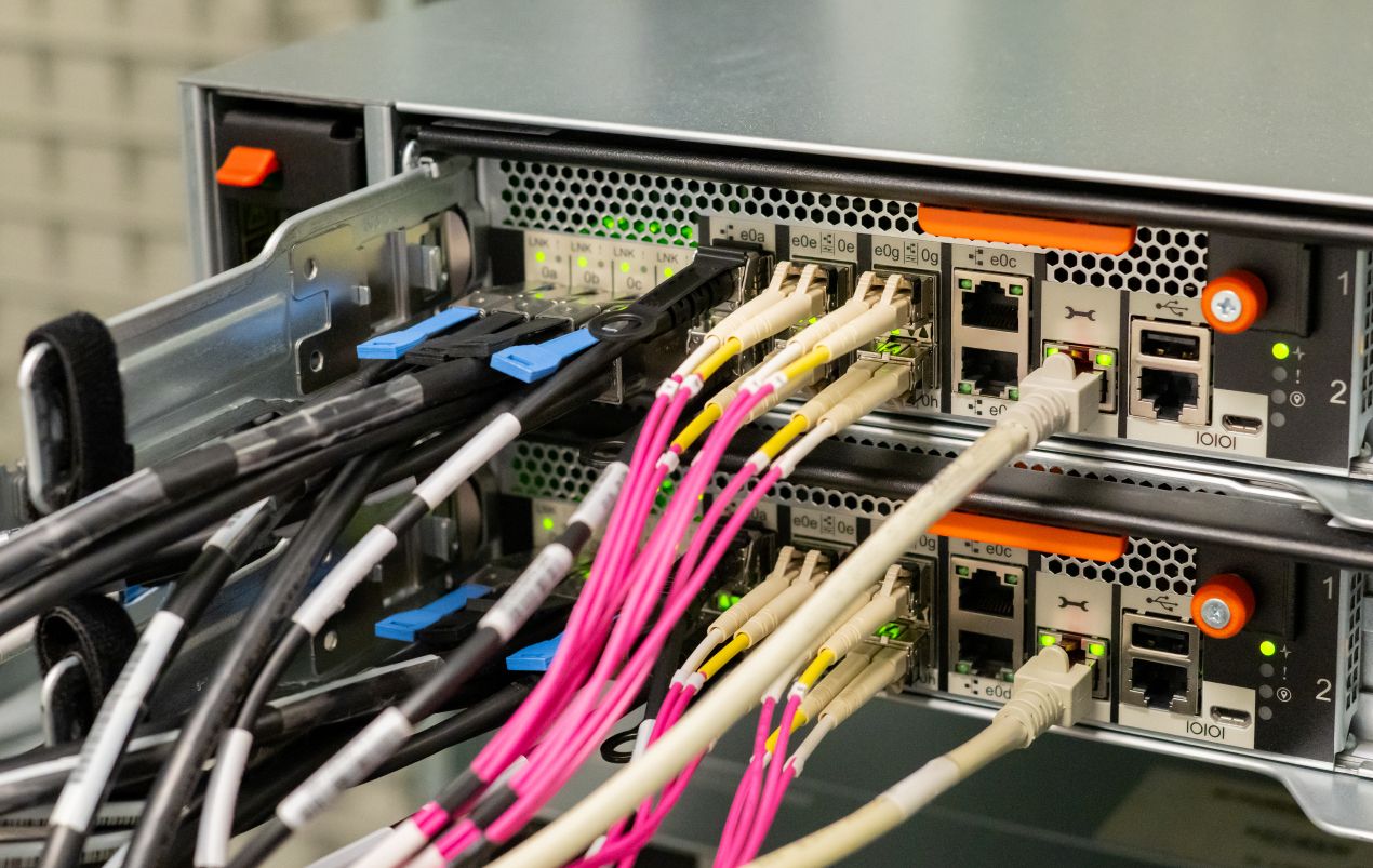 Glasfaserkabel und LWL Verlegekabel angeschlossen an Serverrack mit aktiver Netzwerktechnik