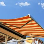 Gestreifte Markise auf sonnigem Balkon ausgefahren | Sonnenschutz Markisen