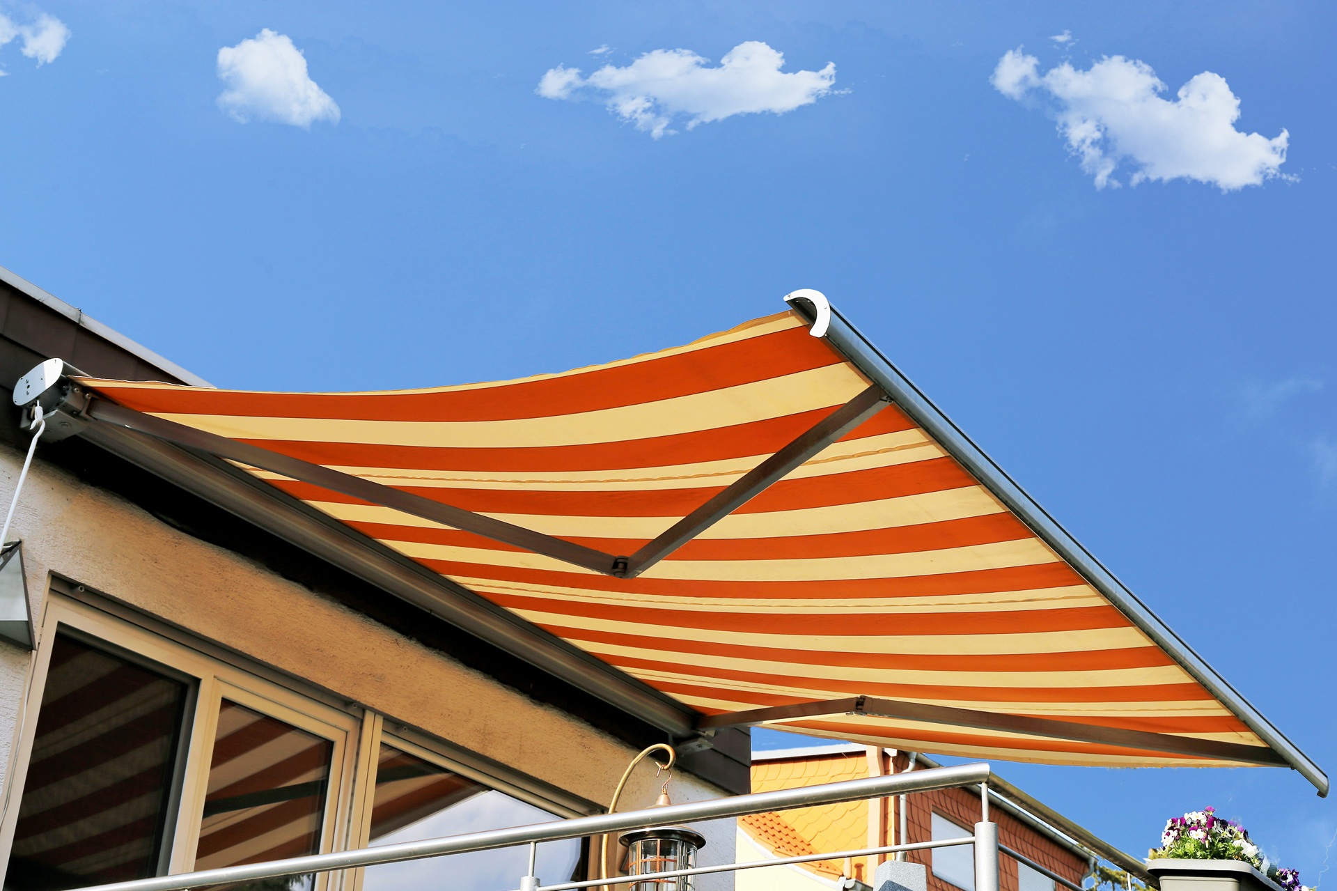 Gestreifte Markise auf sonnigem Balkon ausgefahren | Sonnenschutz Markisen