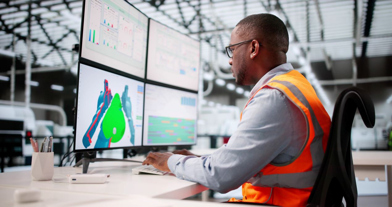 Ingenieur entwickelt Fraesteile am Computer mit CAD-Software in automatisierter Werkstatt